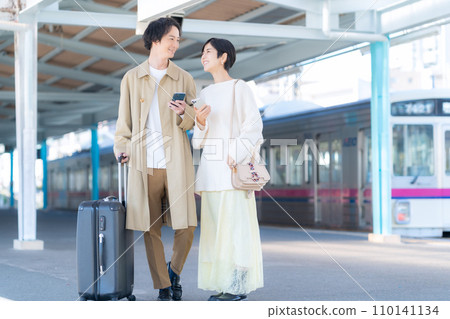 A young couple going on a train trip. Photography provided by Keio Electric Railway Co., Ltd. 110141134