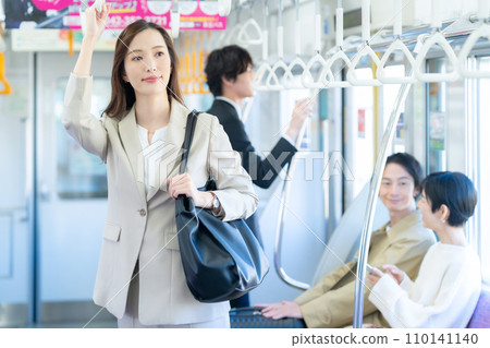 A young business woman commuting by train. Photography provided by Keio Electric Railway Co., Ltd. 110141140