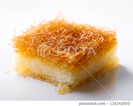 Close-up of Arabic dessert Kunafa on a white background. Close-up of Arabic dessert Kunafa on a white background. 110142650