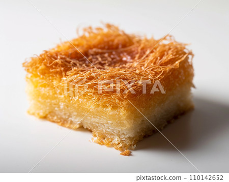 Close-up of Arabic dessert Kunafa on a white background. Close-up of Arabic dessert Kunafa on a white background. 110142652