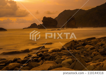 Sunset at the rocky beach in Papuma, Jember, East Java, Indonesia 110144318