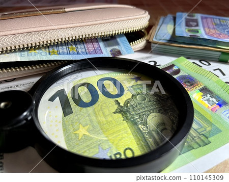 Magnifying glass on different Euro banknotes Magnifying glass on different Euro banknotes 110145309