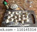 Homemade raw dumplings with meat on a cutting board on the table 110145314
