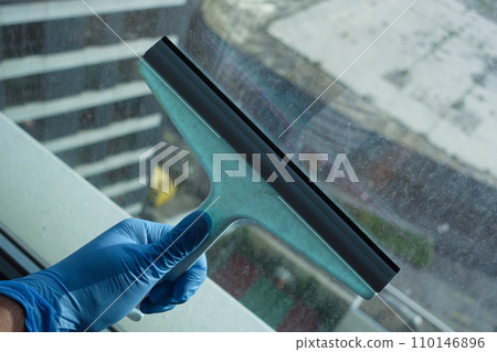 person hand in gloves cleaning window glass person hand in gloves cleaning window glass 110146896