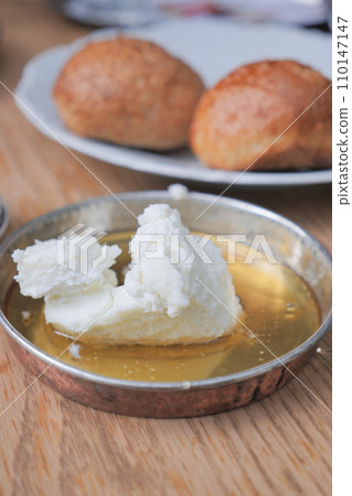 butter cream and honey in a bowl on table . 110147147