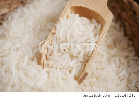 Raw white rice on a wooden spoon 110147213