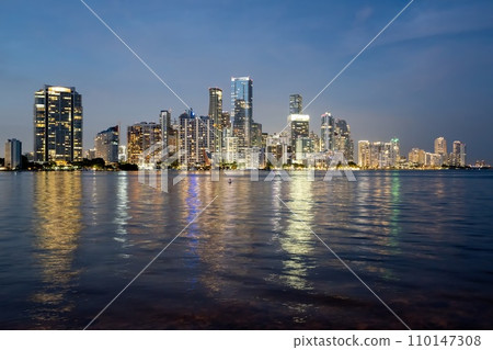 Miami, Florida skyline and lights reflected in Biscayne Bay in evening twilight. Miami, Florida skyline and lights reflected in Biscayne Bay in evening twilight. 110147308