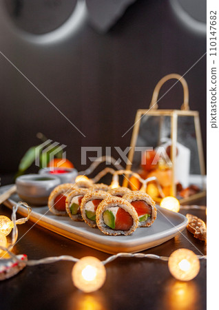 Classic sushi roll set in sesame with salmon, avocado and cream cheese. 110147682