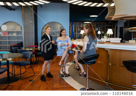 Secretaries have pleasant conversations at cafe break Secretaries have pleasant conversations at cafe break 110148016