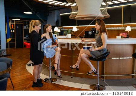 Stylish colleagues smile sitting in office near wooden table Stylish colleagues smile sitting in office near wooden table 110148018