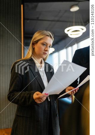 Concentrated female entrepreneur checks data in documents Concentrated female entrepreneur checks data in documents 110148106