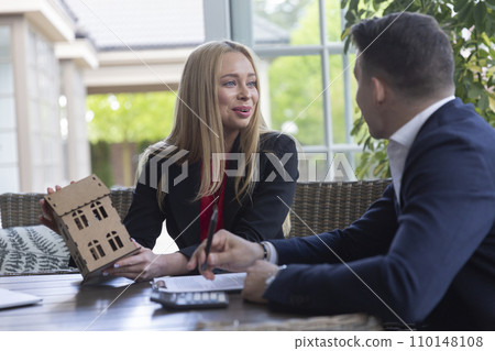 Smiling realtor helps businessman with choosing house Smiling realtor helps businessman with choosing house 110148108