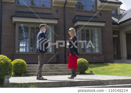 Blonde lady and estate agent observe new residence Blonde lady and estate agent observe new residence 110148224