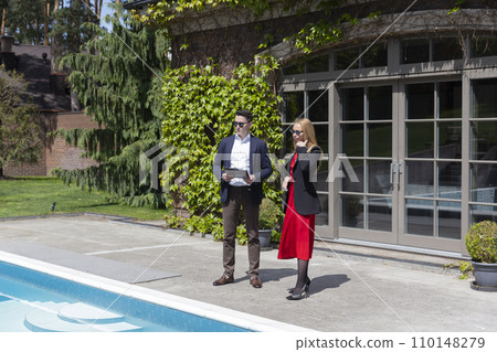 Realtor and potential client observe swimming pool Realtor and potential client observe swimming pool 110148279