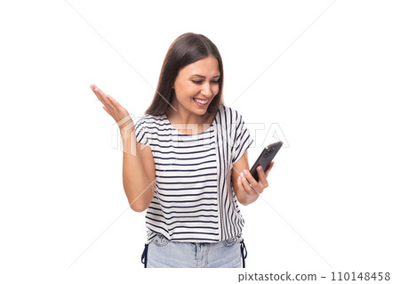 30 year old pretty brunette model woman with long straight hair looks into a mobile phone with a 110148458