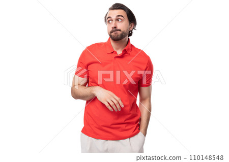 young brutal caucasian brunette man with a beard wearing a corporate color t-shirt on a studio 110148548