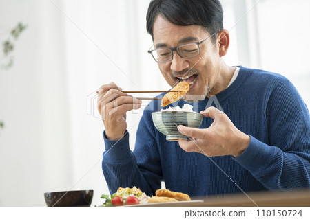 A man in his mid-50s eating pork cutlet 110150724