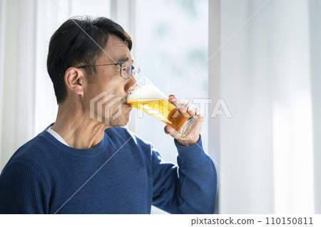 A man in his mid-50s drinking beer A man in his mid-50s drinking beer 110150811