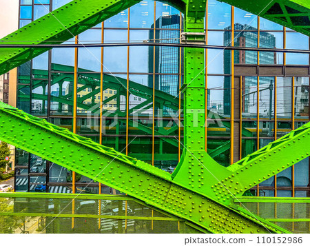 The green railway bridge, the train reflected in the window of the building, the big city, and me. The green railway bridge, the train reflected in the window of the building, the big city, and me. 110152986