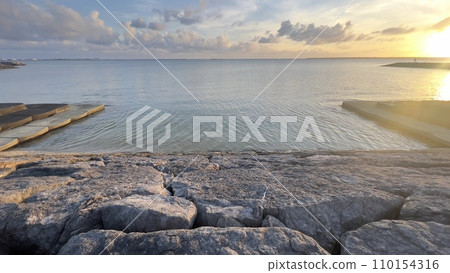 Beautiful and artistic coastline of Ishigaki Island and anglers at sunset 110154316
