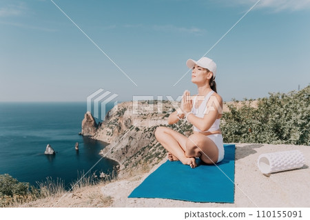 Fitness woman sea. Outdoor workout on yoga mat roller in park near to ocean beach. Female fitness pilates yoga routine concept. Healthy lifestyle. Happy fit woman exercising with rubber band in park. 110155091