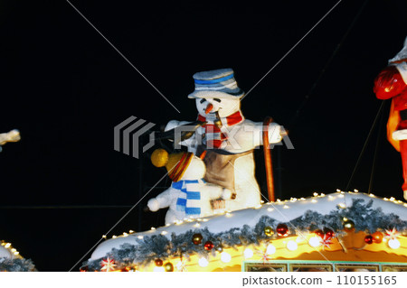 On Christmas night, a snowman and his child happily talk to each other. Looks shining in the spotlight On Christmas night, a snowman and his child happily talk to each other. Looks shining in the spotlight 110155165