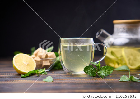 natural organic herbal tea with lemon and mint in glass teapot on a wooden table natural organic herbal tea with lemon and mint in glass teapot on a wooden table 110155632