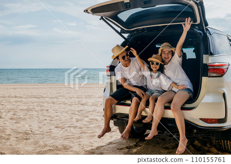 Family Day. Father, Mother and daughter enjoying road trip sitting on family back car raise hand up, Happy people having fun in summer vacation on beach, Family traveling in holiday at sea beach 110155761