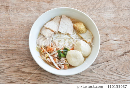 boiled white vermicelli noodles with slice pork and ball couple fried fish line in clear soup on bowl  boiled white vermicelli noodles with slice pork and ball couple fried fish line in clear soup on bowl  110155987