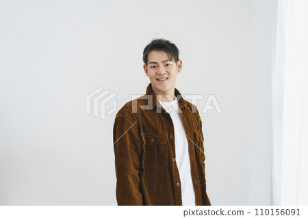 A man in his 30s smiling at the camera, white background portrait 110156091