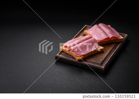 Delicious sandwich with toast bread, ham, tomatoes, salt and spices Delicious sandwich with toast bread, ham, tomatoes, salt and spices 110159521