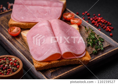 Delicious sandwich with toast bread, ham, tomatoes, salt and spices Delicious sandwich with toast bread, ham, tomatoes, salt and spices 110159527