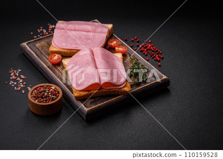 Delicious sandwich with toast bread, ham, tomatoes, salt and spices 110159528