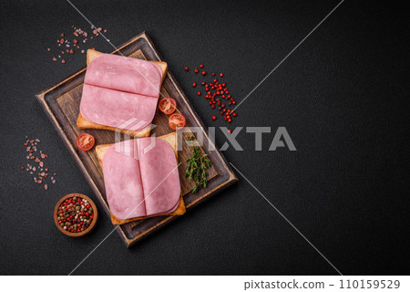 Delicious sandwich with toast bread, ham, tomatoes, salt and spices Delicious sandwich with toast bread, ham, tomatoes, salt and spices 110159529