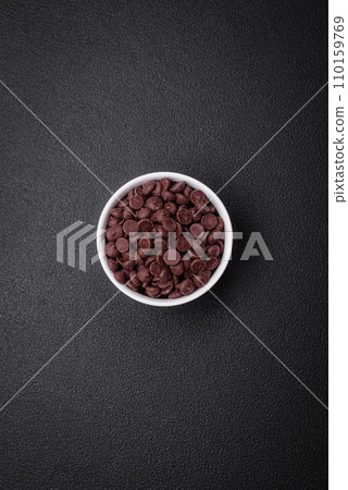 Round granules of sweet confectionery chocolate as an ingredient for preparing delicious desserts Round granules of sweet confectionery chocolate as an ingredient for preparing delicious desserts 110159769