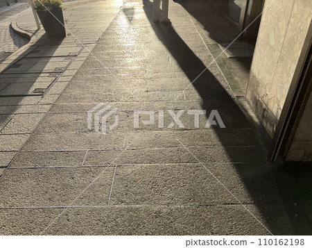 黃昏時分，陰影映在鵝卵石路面上 110162198