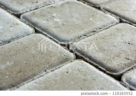 Background from a gray sidewalk path. Close-up of concrete paving slab bricks. Background from a gray sidewalk path. Close-up of concrete paving slab bricks. 110163552