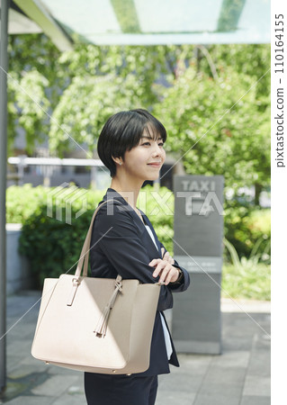 Female office worker in her 30s waiting for a taxi 110164155