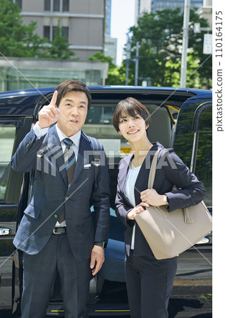 A male office worker in his 50s and a female office worker in her 30s using a taxi A male office worker in his 50s and a female office worker in her 30s using a taxi 110164175