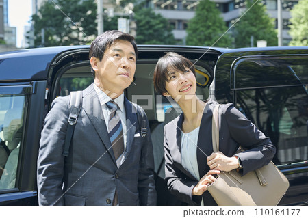 A male office worker in his 50s and a female office worker in her 30s using a taxi A male office worker in his 50s and a female office worker in her 30s using a taxi 110164177