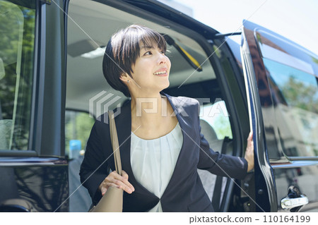 Female office worker in her 30s getting off the taxi 110164199