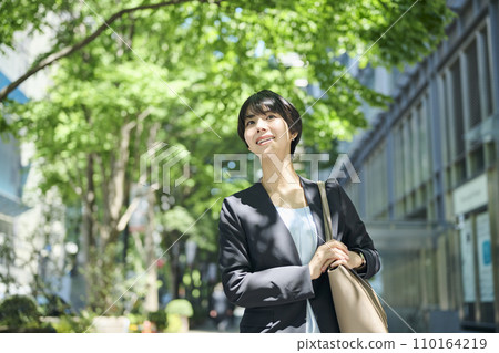 Female office worker in her 30s walking in the business district 110164219