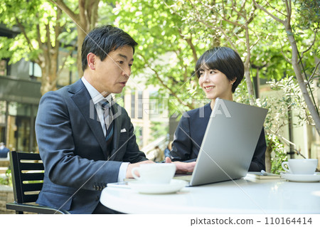 一名50多歲的男性上班族和一名30多歲的女性上班族在露台開會 一名50多歲的男性上班族和一名30多歲的女性上班族在露台開會 110164414