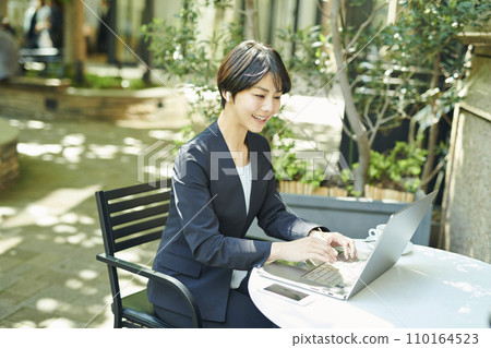 一名30多歲的女上班族在露臺上開網路會議 一名30多歲的女上班族在露臺上開網路會議 110164523