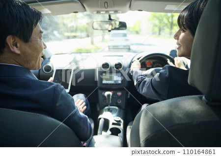 A male office worker in his 50s and a female office worker in her 30s talking in the car A male office worker in his 50s and a female office worker in her 30s talking in the car 110164861