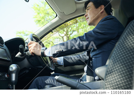 Office worker in his 50s driving a car 110165180