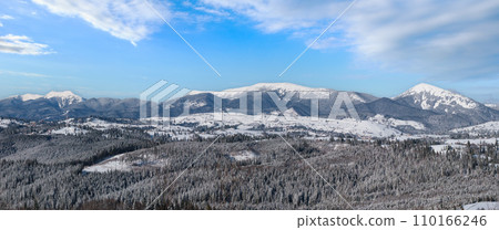 Winter remote alpine village outskirts, countryside hills, groves and farmlands view from mountain slope 110166246