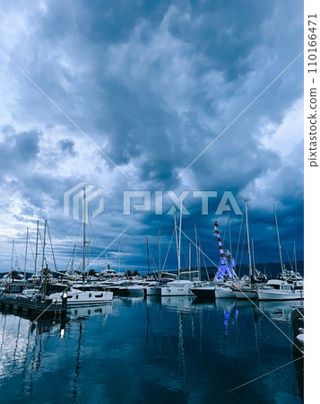 Marina with sailing yachts and port crane against the twilight sky Marina with sailing yachts and port crane against the twilight sky 110166471