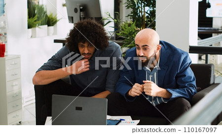 Excited managers celebrating victory in coworking space, checking monthly online reports. Business partners doing highfive feeling proud with successful win, development collab achievement. 110167097