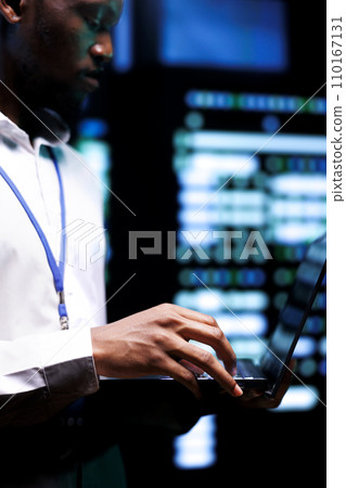 Admin checking event logs and diagnostic tools using laptop to identify server issues root cause. Technician looking over supercomputer operating system configuration settings 110167131